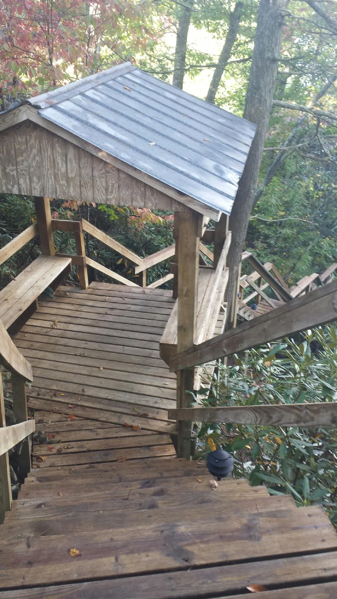 Metal roofed shelter over wooden steps on a wooded walkway — Skylight Repair & Installation work by our crew in Port Ewen