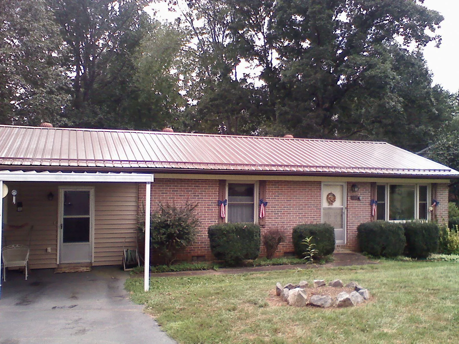 Bronze metal roof and carport on a brick ranch home — Roof Repair work by our crew in Port Ewen
